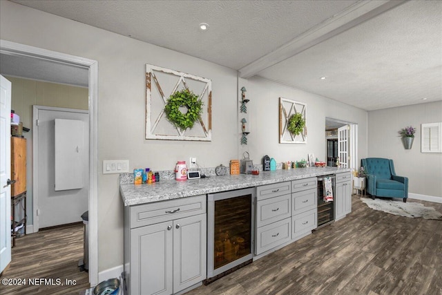 kitchen with dark hardwood / wood-style flooring, a textured ceiling, and wine cooler