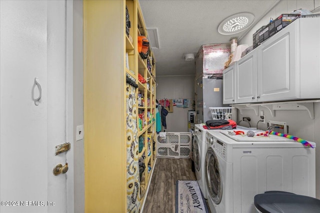 laundry room with washer and clothes dryer, dark hardwood / wood-style floors, cabinets, and a textured ceiling