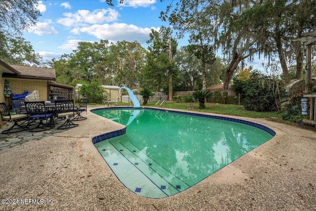 view of swimming pool featuring a patio and a water slide