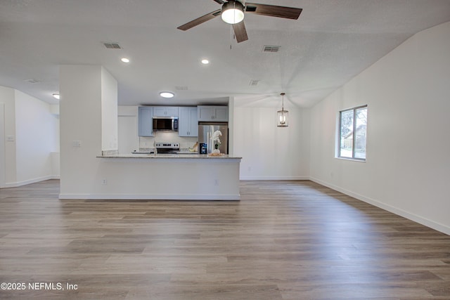 unfurnished living room featuring baseboards, a ceiling fan, visible vents, and light wood-style floors