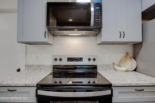 kitchen with appliances with stainless steel finishes, ventilation hood, and light stone counters