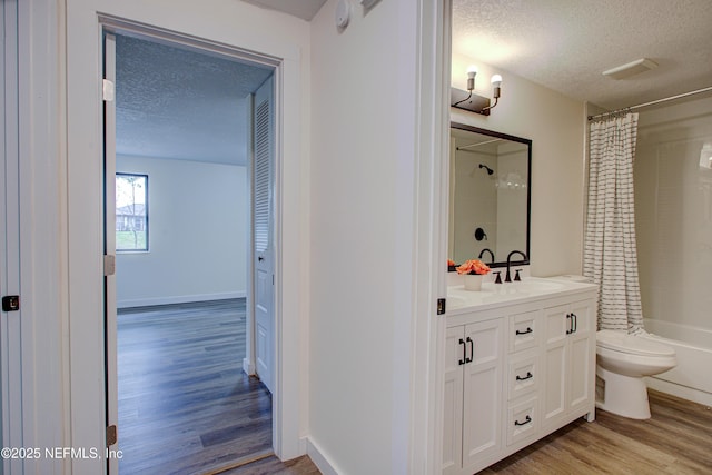 bathroom featuring visible vents, toilet, wood finished floors, a textured ceiling, and vanity