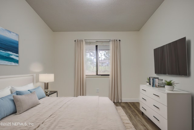 bedroom with baseboards and wood finished floors