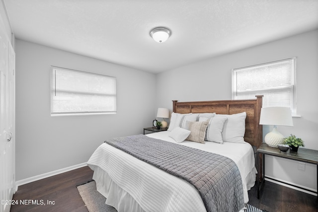 bedroom with dark hardwood / wood-style flooring and multiple windows