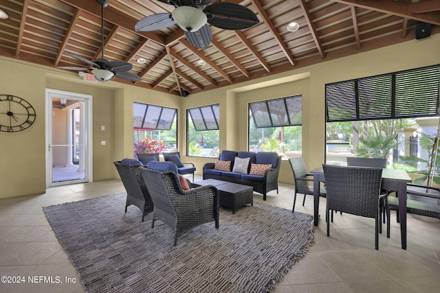 sunroom with lofted ceiling with beams, ceiling fan, and wooden ceiling