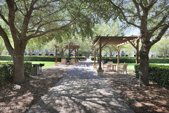 view of community featuring a pergola and a yard