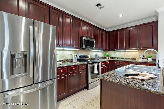 kitchen with backsplash, dark stone counters, stainless steel appliances, sink, and light tile patterned flooring