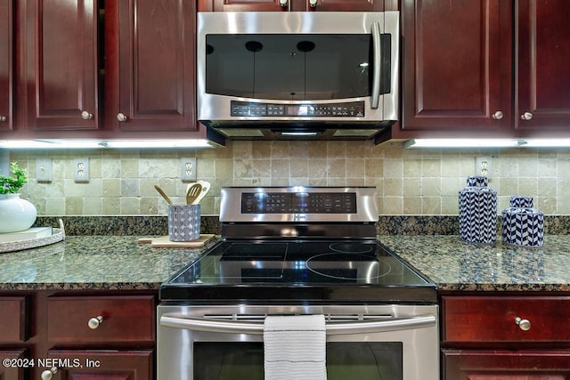 kitchen featuring appliances with stainless steel finishes, tasteful backsplash, and dark stone counters