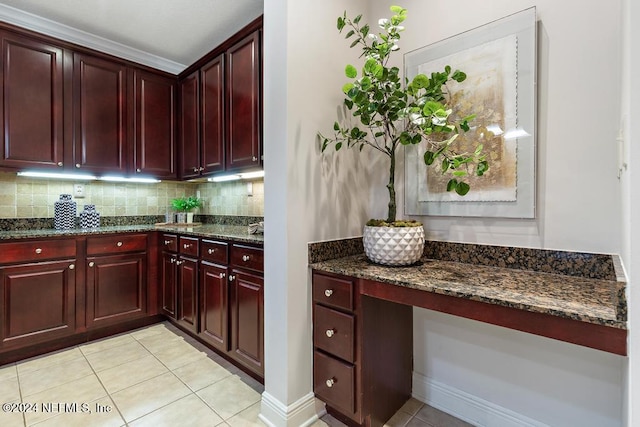 kitchen with backsplash, dark stone countertops, and light tile patterned flooring