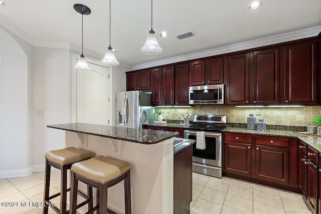 kitchen featuring a center island, dark stone countertops, appliances with stainless steel finishes, and tasteful backsplash