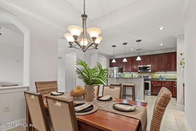 tiled dining area featuring ornamental molding and a chandelier