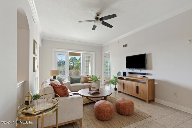 tiled living room with a textured ceiling, ceiling fan, and crown molding