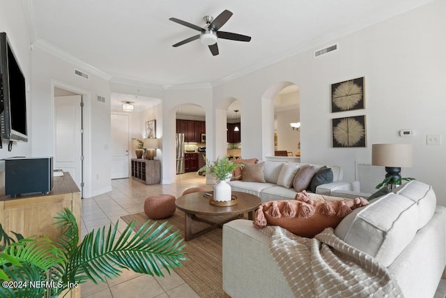 living room featuring light tile patterned floors, ceiling fan with notable chandelier, and ornamental molding