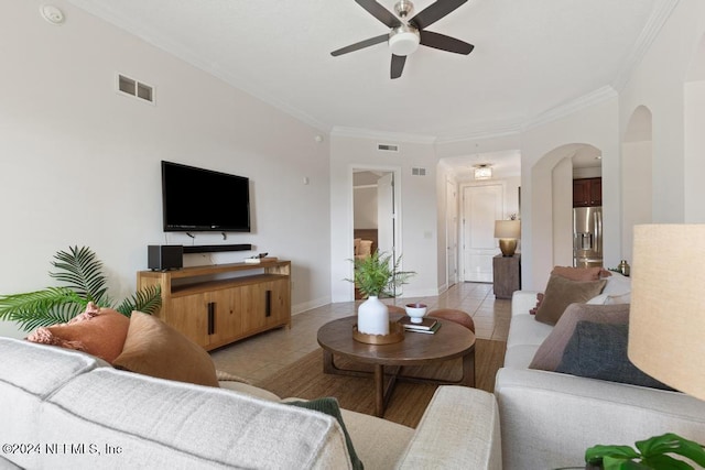 living room featuring ceiling fan, light tile patterned floors, and crown molding