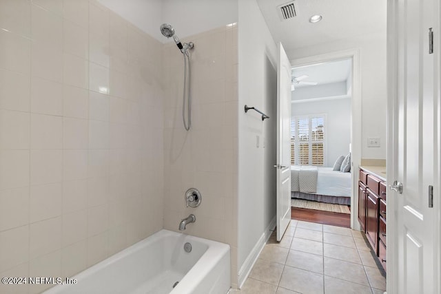 bathroom featuring tile patterned flooring, tiled shower / bath, vanity, and ceiling fan