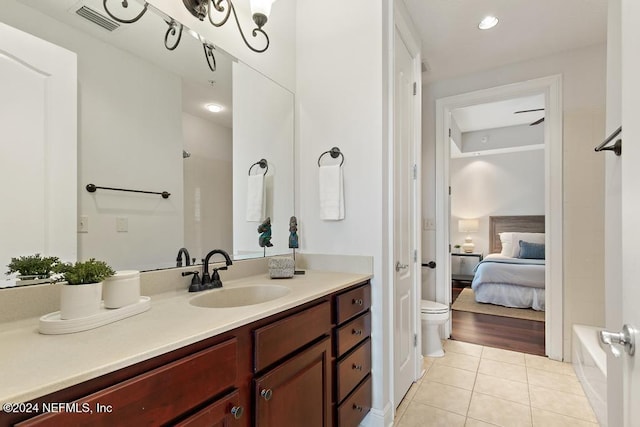 bathroom featuring a bath, vanity, hardwood / wood-style flooring, and toilet