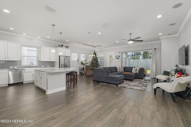 living room featuring a wealth of natural light, crown molding, ceiling fan, and dark hardwood / wood-style floors