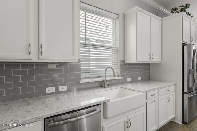 kitchen with light stone counters, stainless steel appliances, dark wood-type flooring, sink, and white cabinetry