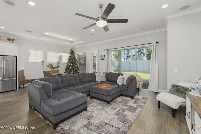 living room with ceiling fan with notable chandelier, dark hardwood / wood-style floors, and ornamental molding