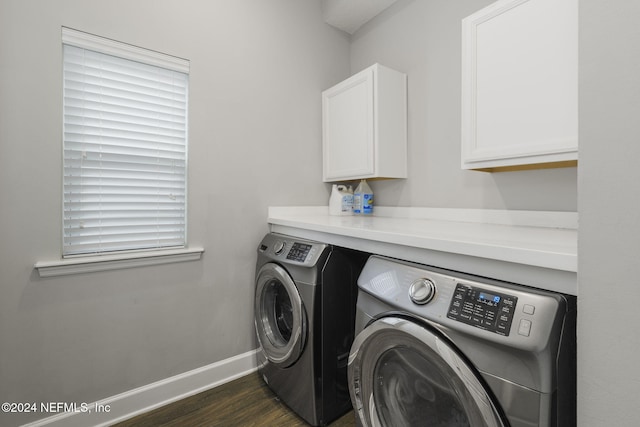 washroom featuring washer and dryer, dark wood-type flooring, and cabinets