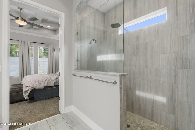 bathroom with tile patterned flooring, ceiling fan, a tile shower, and ornamental molding