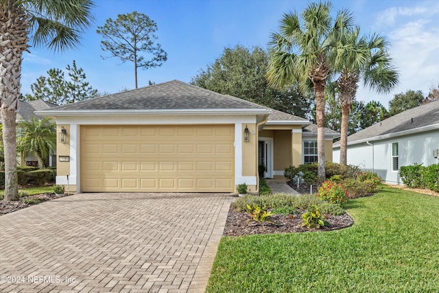 single story home featuring a garage and a front yard