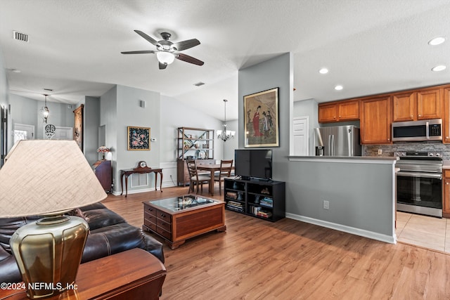 living room featuring a textured ceiling, vaulted ceiling, and light hardwood / wood-style flooring