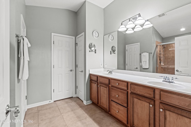 bathroom featuring tile patterned floors, a shower with door, and vanity