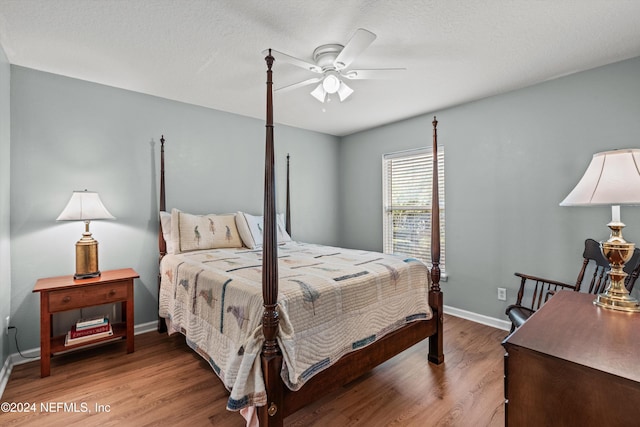 bedroom with ceiling fan, a textured ceiling, and hardwood / wood-style flooring