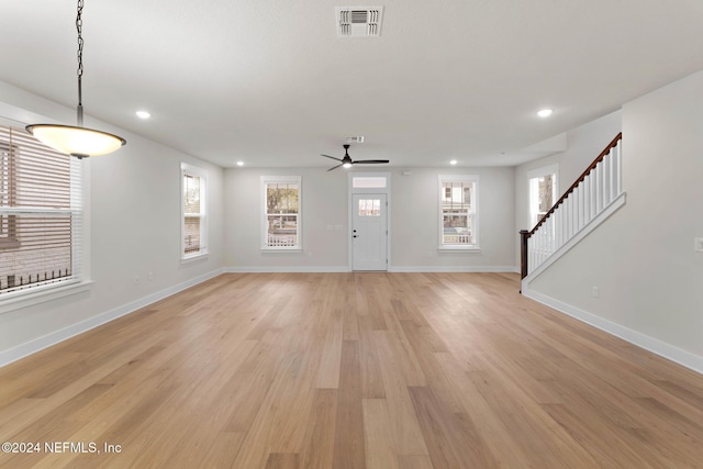 unfurnished living room with ceiling fan, a healthy amount of sunlight, and light wood-type flooring