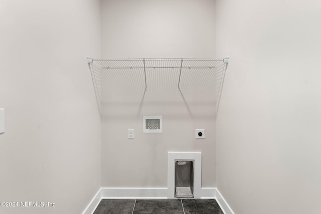 washroom with hookup for an electric dryer, washer hookup, and dark tile patterned flooring