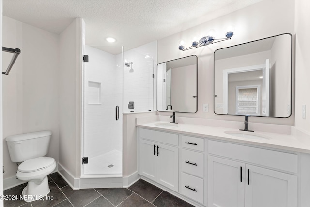 bathroom featuring vanity, a textured ceiling, tile patterned flooring, toilet, and a shower with shower door