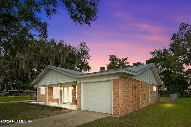 ranch-style home with a garage and a yard