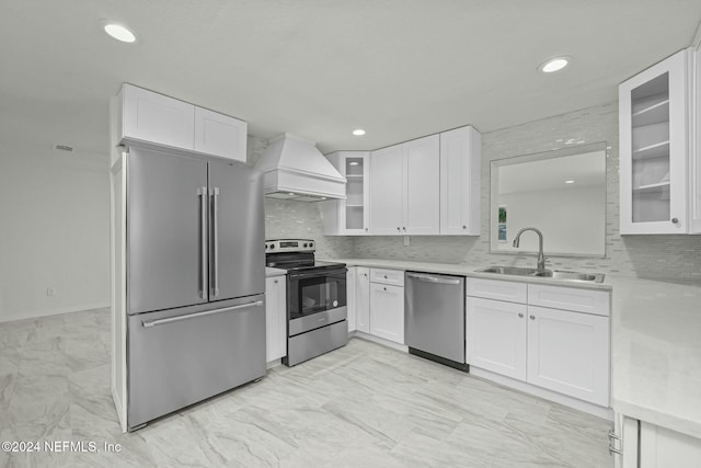 kitchen with white cabinets, sink, custom range hood, and stainless steel appliances