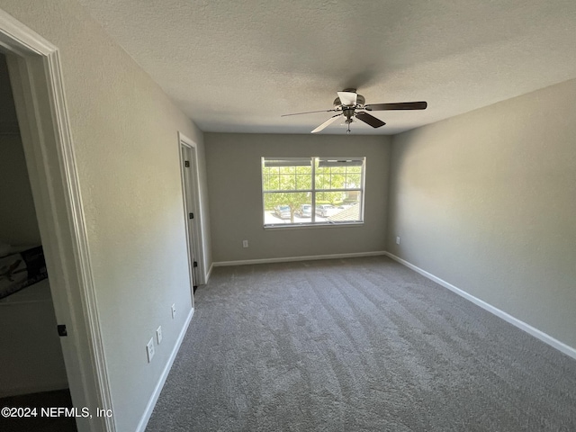 spare room with ceiling fan, carpet floors, and a textured ceiling