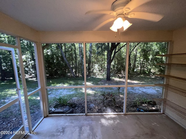 unfurnished sunroom featuring ceiling fan