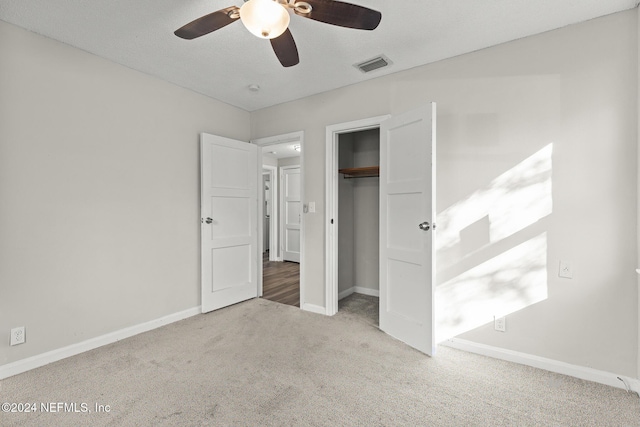 unfurnished bedroom with light carpet, a closet, and ceiling fan