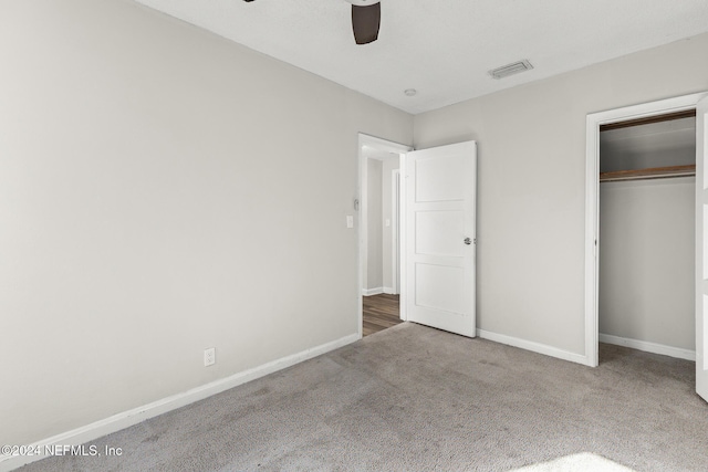 unfurnished bedroom with ceiling fan, carpet floors, and a closet