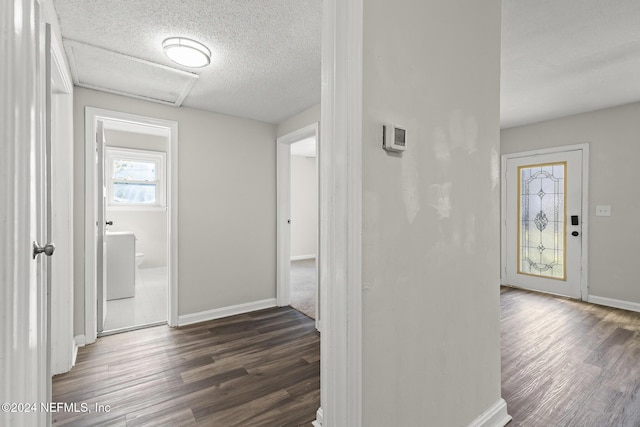 corridor with dark hardwood / wood-style floors and a textured ceiling