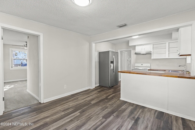 kitchen with wood counters, stainless steel fridge, stove, dark wood-type flooring, and white cabinets