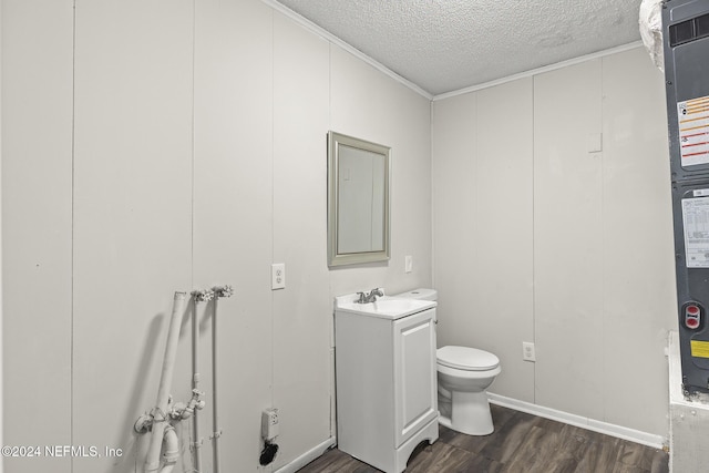 bathroom with vanity, a textured ceiling, crown molding, hardwood / wood-style floors, and toilet