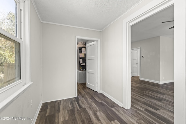 hall featuring dark hardwood / wood-style flooring, a textured ceiling, and ornamental molding