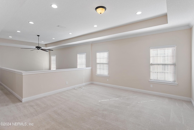 carpeted spare room with ceiling fan, a textured ceiling, and ornamental molding