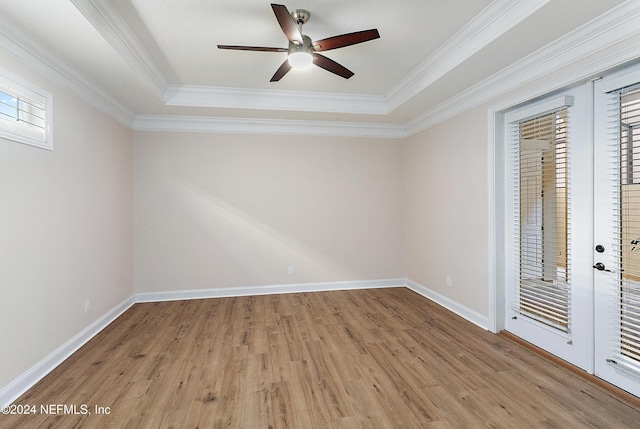 unfurnished bedroom featuring hardwood / wood-style floors, a raised ceiling, and ornamental molding