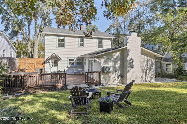 rear view of house featuring a lawn and a wooden deck