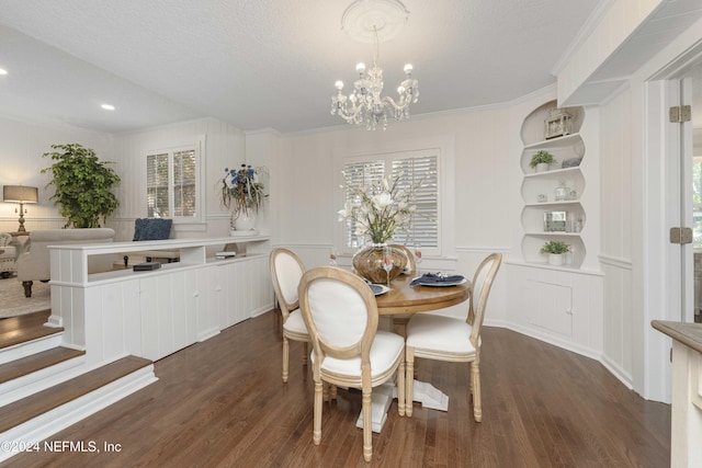 dining room featuring a chandelier, crown molding, dark wood-type flooring, and a textured ceiling