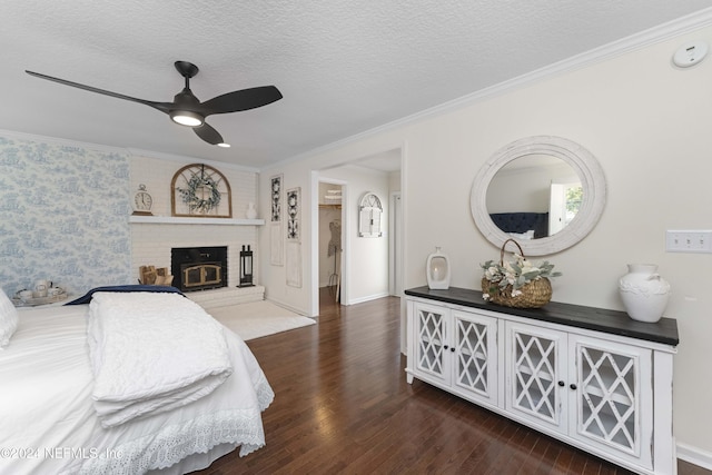 bedroom with a textured ceiling, ceiling fan, dark hardwood / wood-style floors, and ornamental molding