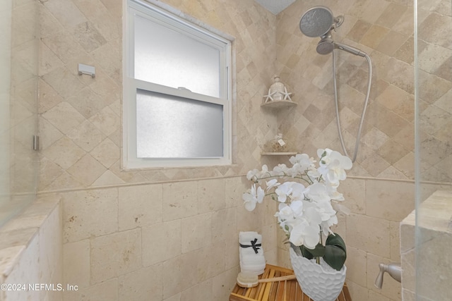 bathroom featuring a tile shower and a wealth of natural light