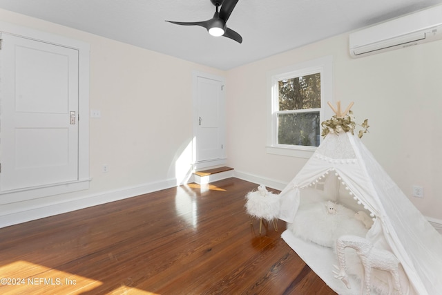 spare room featuring a wall unit AC, ceiling fan, and dark wood-type flooring