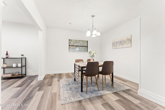 dining area featuring a notable chandelier and light wood-type flooring